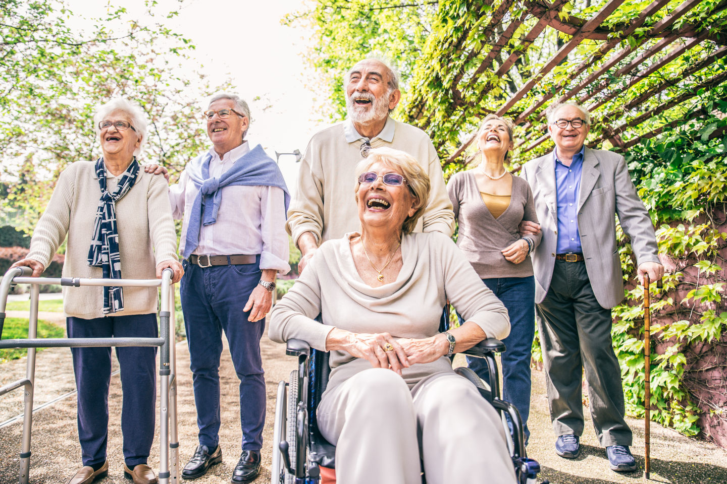 Group of senior people with some diseases walking outdoors - Mature group of friends spending time together