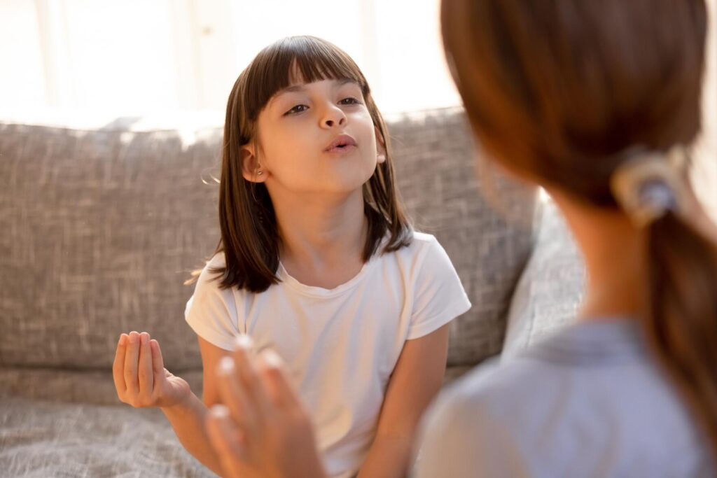 Cute stuttering child girl speaking learning correct articulation or singing warm-up with speech therapist music teacher doing exercises at private lesson, speech language therapy for kid concept